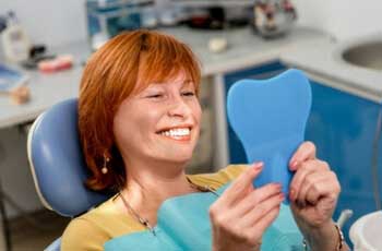 Woman looking at her teeth at the dentist clinic